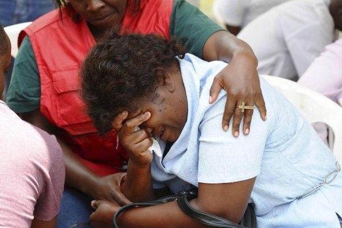A relative is assisted by Red Cross staff as bodies of the students killed in Thursday's attack arrive at the Chiromo Mortuary in Nairobi on Friday.