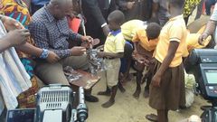 President Mahama distributing sandals to students