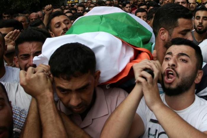 Palestinians carry the body of Aisha Rabi who died after a stone-throwing attack, during her funeral in the West Bank village of Bidiya on October 13, 2018