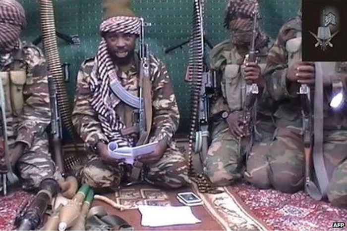 Boko Haram leader Abubakar Shekau [with a book], flanked by his men