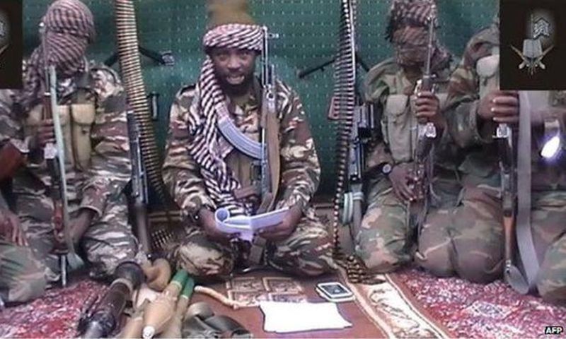 Boko Haram leader Abubakar Shekau [with a book], flanked by his men