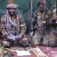 Boko Haram leader Abubakar Shekau [with a book], flanked by his men