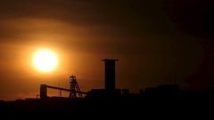 The sun sets behind a shaft outside the mining town of Carletonville, west of Johannesburg, July 7 2015. REUTERS/Siphiwe Sibeko