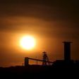 The sun sets behind a shaft outside the mining town of Carletonville, west of Johannesburg, July 7 2015. REUTERS/Siphiwe Sibeko