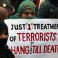 A supporter of political party Pakistan Awami Tehreek (PAT), holds a sign with others to condemn the attack by Taliban gunmen on the Army Public School in Peshawar, during a rally in Lahore December 21, 2014.