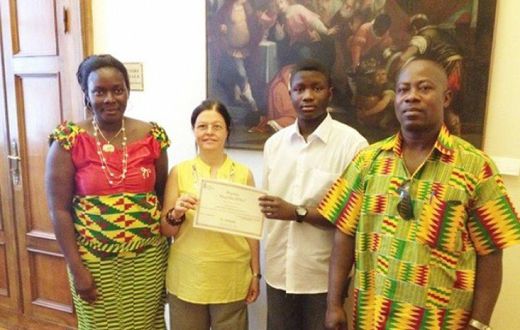 An official of the Santa Lucia education directorate (second left) presenting a certificate of merit to Master Emmanuel Sarpong Agyemang. Flanking them are the parents of Master Agyemang