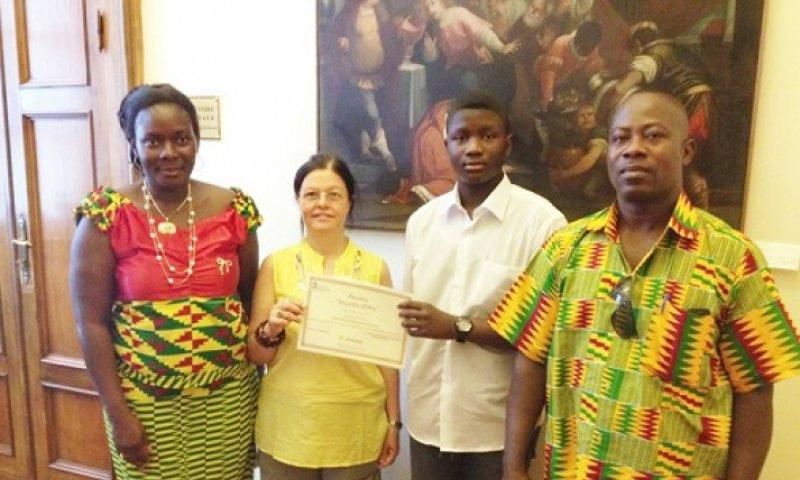 An official of the Santa Lucia education directorate (second left) presenting a certificate of merit to Master Emmanuel Sarpong Agyemang. Flanking them are the parents of Master Agyemang