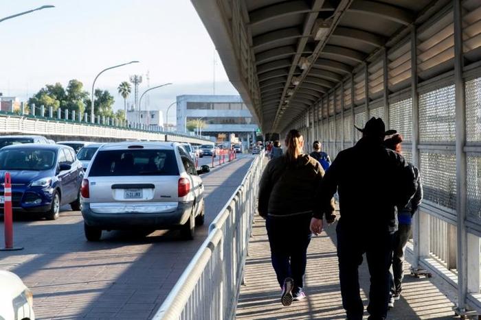 People walk and drive across the international bridge on the US/Mexico border in Laredo, Texas, on January 13, 2019
