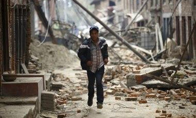 A man runs through ruins as aftershocks hit Kathmandu.
