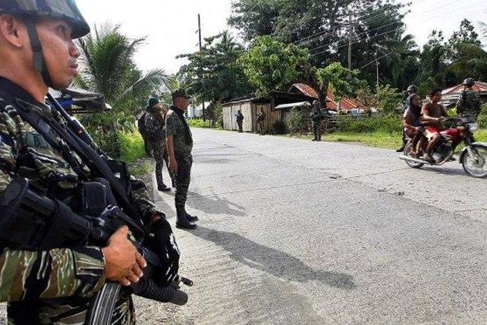 Members of Muslim rebel group Moro Islamic Liberation Front stand guard in the town of Sultan Kudarat ahead of the surrender of combatants with their firearms to President Benigno Aquino III