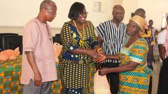  Nana Oye Lithur  presenting items and free NHIS card to an elderly woman
