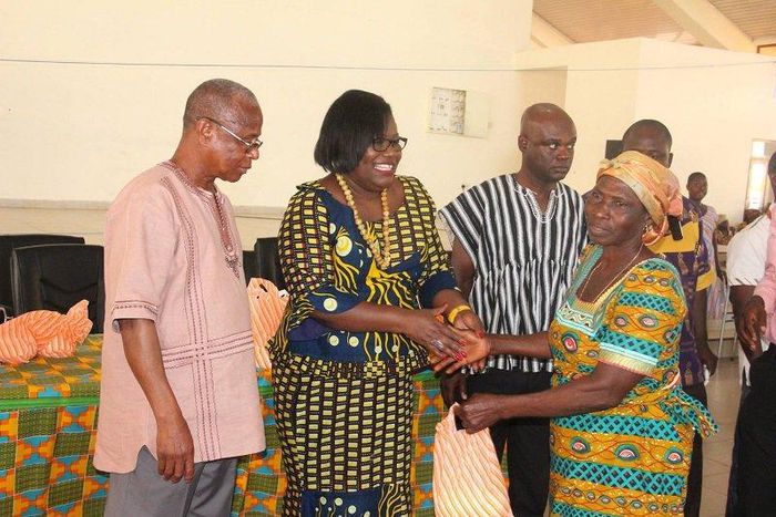  Nana Oye Lithur  presenting items and free NHIS card to an elderly woman