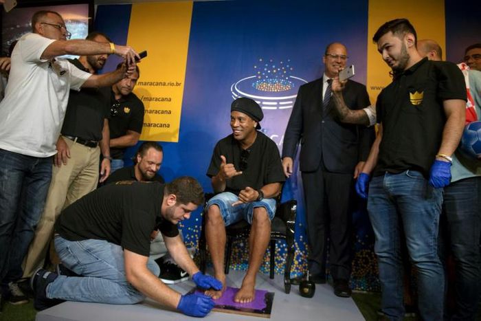 Brazil great Ronaldinho gestures during a ceremony to stamp his footprints at Maracana Stadium's Hall of Fame