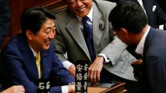 Financial Minister Taro Aso, center, and Japanese Prime Minister Shinzo Abe, left, share a light moment during a plenary session at the lower house in Tokyo, Thursday, July 16, 2015.