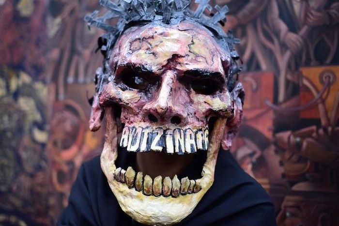 A protester in Mexico City commemorates the first anniversary of the disappearance of the 43 students from Ayotzinapa. Protesters have tackled the issue in striking and original visual ways — such as this figure, clad in a mask crowned with crucifixes