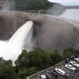 People watch as the spillway gates are opened at Kariba North Bank dam on Lake Kariba