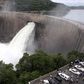 People watch as the spillway gates are opened at Kariba North Bank dam on Lake Kariba