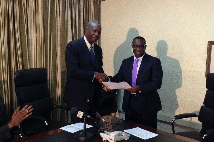 Mr. Dosso (left), presenting the Ecobank Ghana's 2013 dividend to Mr. Thompson of SSNIT