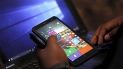 A Microsoft delegate checks applications on a smartphone during the launch of the Windows 10 operating system in Kenya's capital Nairobi, July 29, 2015. REUTERS/Thomas Mukoya