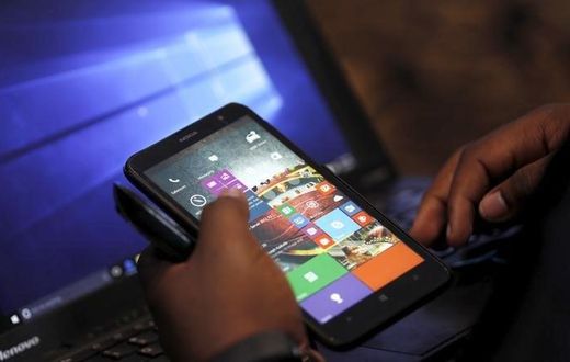 A Microsoft delegate checks applications on a smartphone during the launch of the Windows 10 operating system in Kenya's capital Nairobi, July 29, 2015. REUTERS/Thomas Mukoya