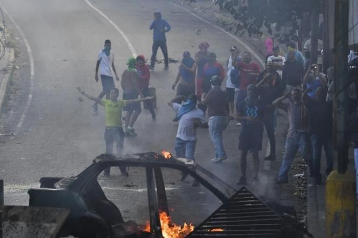 Venezuelans protest near the Cotiza National Guard headquarters in Caracas, where a group of soldiers were arrested on Monday after rising up against President Nicolas Maduro
