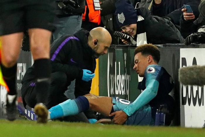 Tottenham midfielder Dele Alli receives medical attention at Craven Cottage