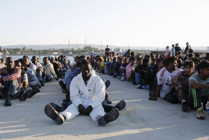 Migrants rest after disembarking in the Sicilian harbour of Augusta, Italy, June 23, 2015.   REUTERS/Antonio Parrinello