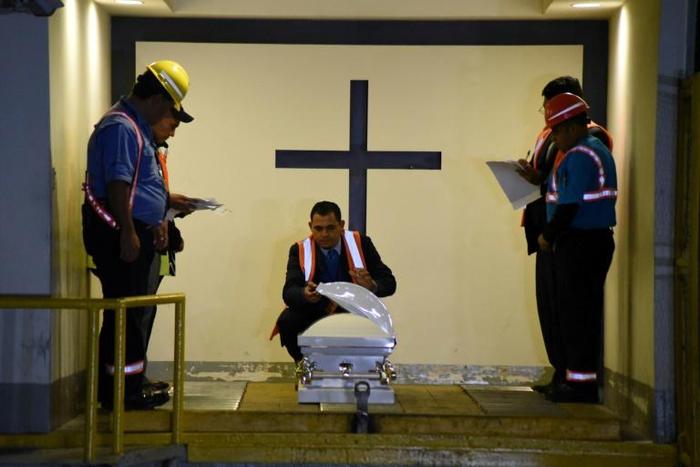 Funeral home employees in Guatemala prepare the coffin holding the repatriated body of eight-year-old migrant Felipe Gomez