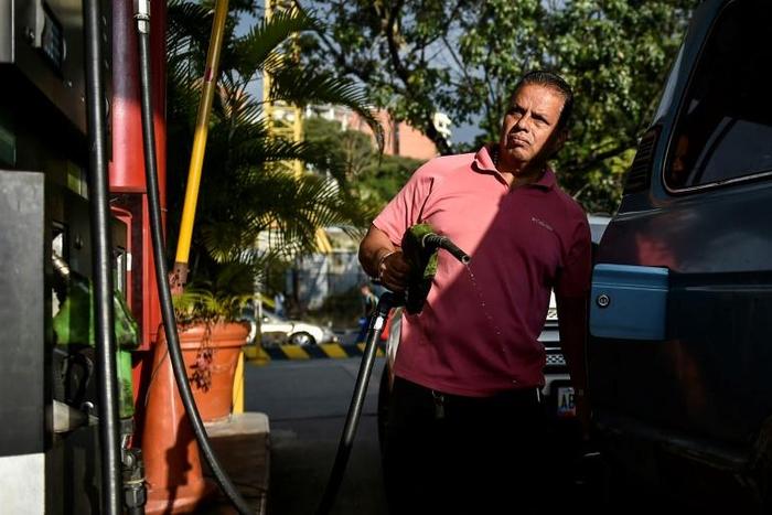 A man pumps fuel at a gas station in Caracas, on January 29, 2019