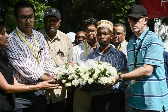 DusitD2 hotel General Manager Michael Metaxas (R), a survivor, placed a wreath with other staff at the gate of the complex in Nairobi where 21 people were killed