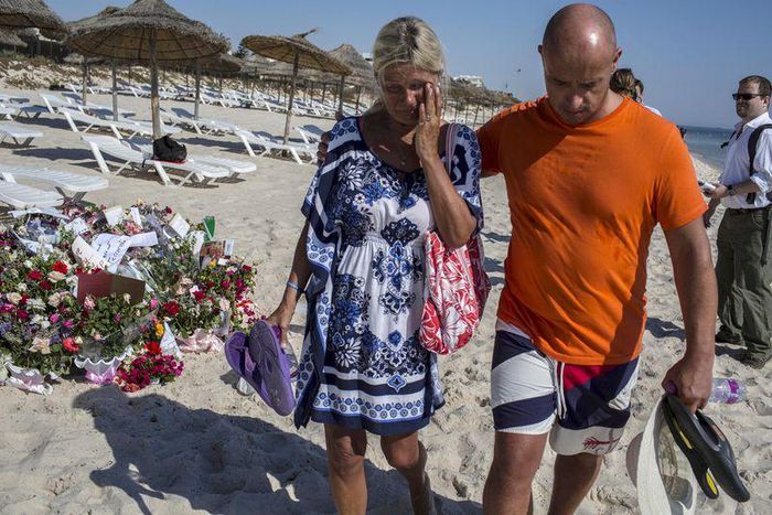 A tourist reacts after paying tribute at a makeshift memorial at the beachside of the Imperial Marhaba resort, which was attacked by a gunman in Sousse, Tunisia, June 29, 2015. REUTERS/Zohra Bensemra