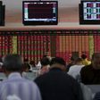 Investors look at computer screens in front of an electronic board showing stock information at a brokerage house in Shanghai, China, July 14, 2015.  REUTERS/Aly Song