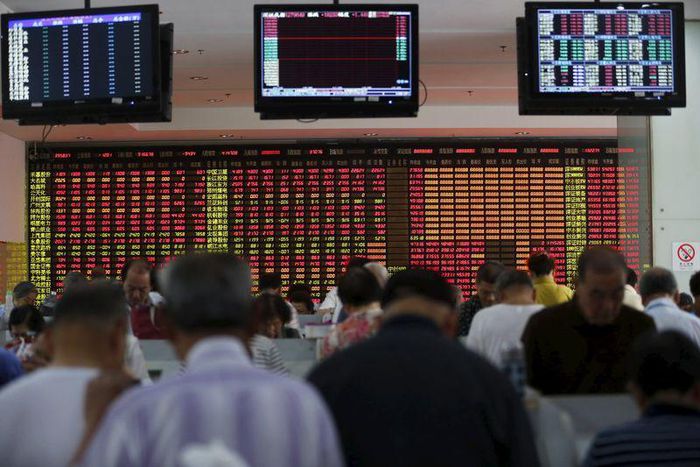 Investors look at computer screens in front of an electronic board showing stock information at a brokerage house in Shanghai, China, July 14, 2015.  REUTERS/Aly Song
