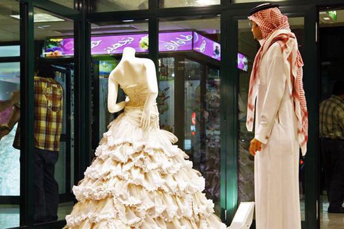 In this Aug. 3, 2008 file photo, a Saudi man stands in front of a wedding dress at a shop in Riyadh, Saudi Arabia.