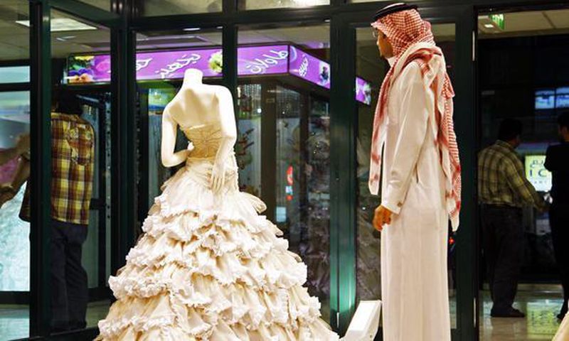 In this Aug. 3, 2008 file photo, a Saudi man stands in front of a wedding dress at a shop in Riyadh, Saudi Arabia.
