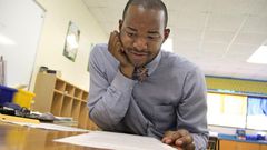 Teacher Omar Currie reads a copy of a complaint a parent filed about him reading the book "King & King to his students