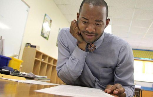 Teacher Omar Currie reads a copy of a complaint a parent filed about him reading the book "King & King to his students