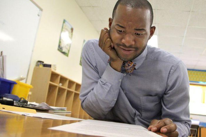 Teacher Omar Currie reads a copy of a complaint a parent filed about him reading the book "King & King to his students