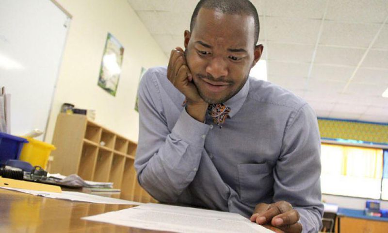 Teacher Omar Currie reads a copy of a complaint a parent filed about him reading the book "King & King to his students