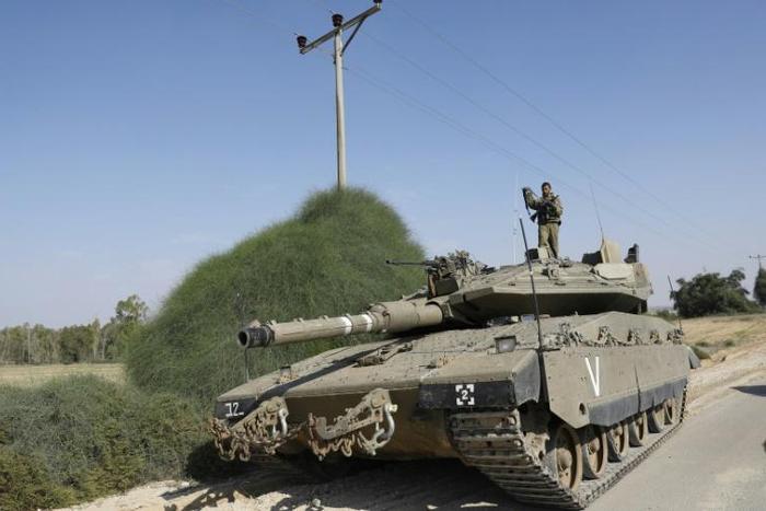 An Israeli soldier stands on a Merkava tank stationed on the Israeli border with the Gaza Strip, on November 13 2018