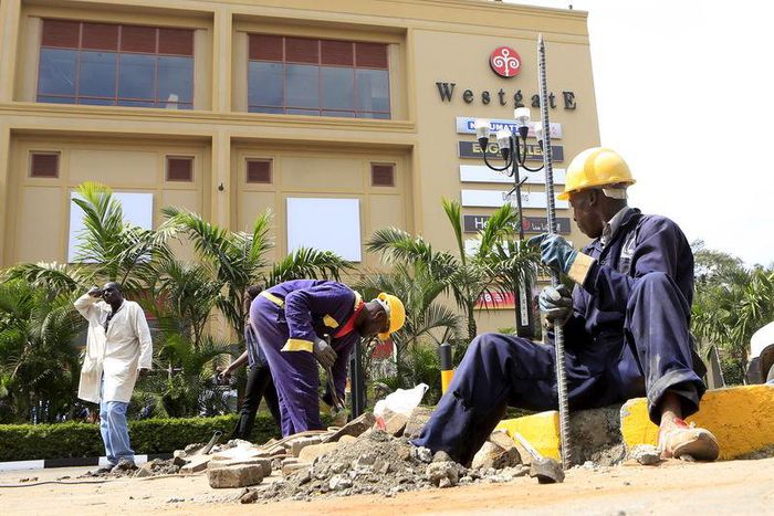 Construction workers dig holes to erect barriers at the reopened Westgate shopping mall, which was closed in the aftermath of an attack by militant gunmen in September 2013 that killed 67 people and injured many more, in capital Nairobi July 14, 2015. ...