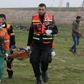 Palestinian paramedics evacuate a protester near the fence separating the Gaza Strip from Israel, east of Gaza City, on February 1, 2019