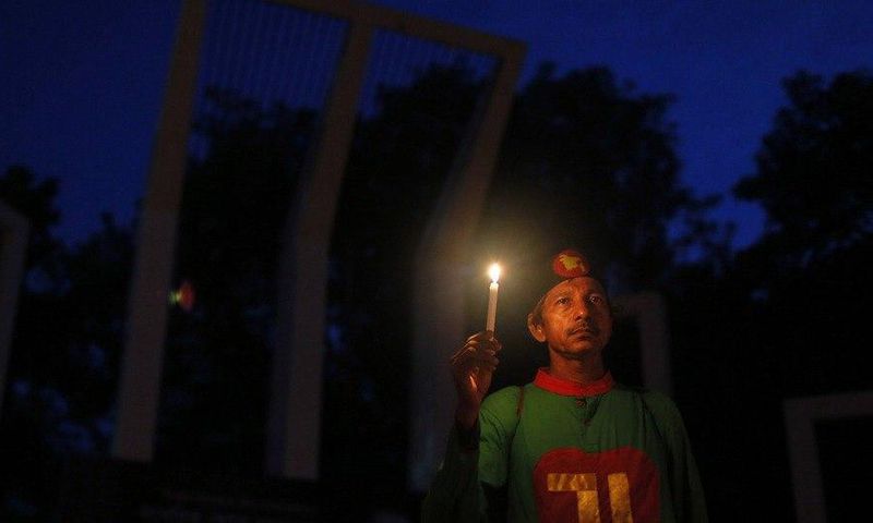 A Bangladeshi activist holds a candle, as they protest against the killing of secular blogger Niloy Chakrabarti in Dhaka, Bangladesh.