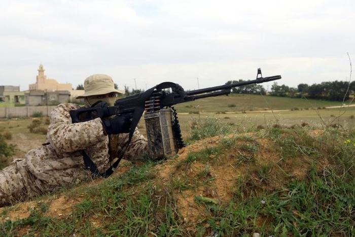 A member of the Tripoli Protection Force militia alliance takes a position south of the Libyan capital during clashes with the Seventh Brigade group