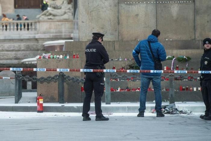 Police officers investigate at the scene where a man set himself on fire in Prague
