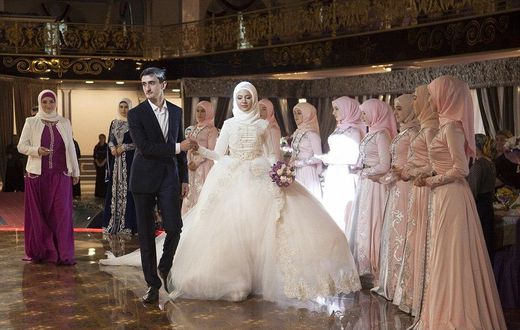 Chechen newlyweds, Zara Khasanova and her groom, prepare to dance during a wedding ceremony in Grozny. Chechen weddings are traditionally paid for by the groom and attended by his family members