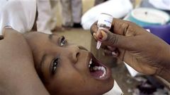 A health worker gives a child an oral polio vaccine in Kano, Nigeria.