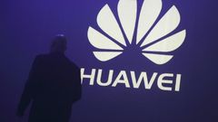 A man walks past a logo during the presentation the Huawei's new smartphone, the Ascend P7, launched by China's Huawei Technologies in Paris, May 7, 2014. REUTERS/Philippe Wojazer/Files