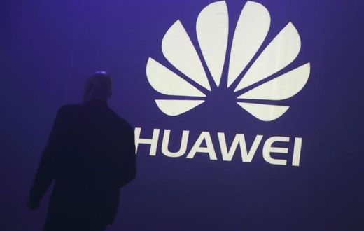 A man walks past a logo during the presentation the Huawei's new smartphone, the Ascend P7, launched by China's Huawei Technologies in Paris, May 7, 2014. REUTERS/Philippe Wojazer/Files