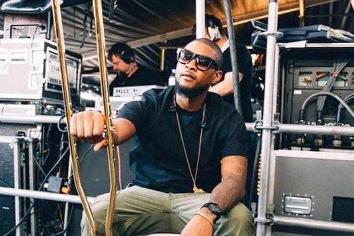 Usher Raymond displaying his gold crutches backstage